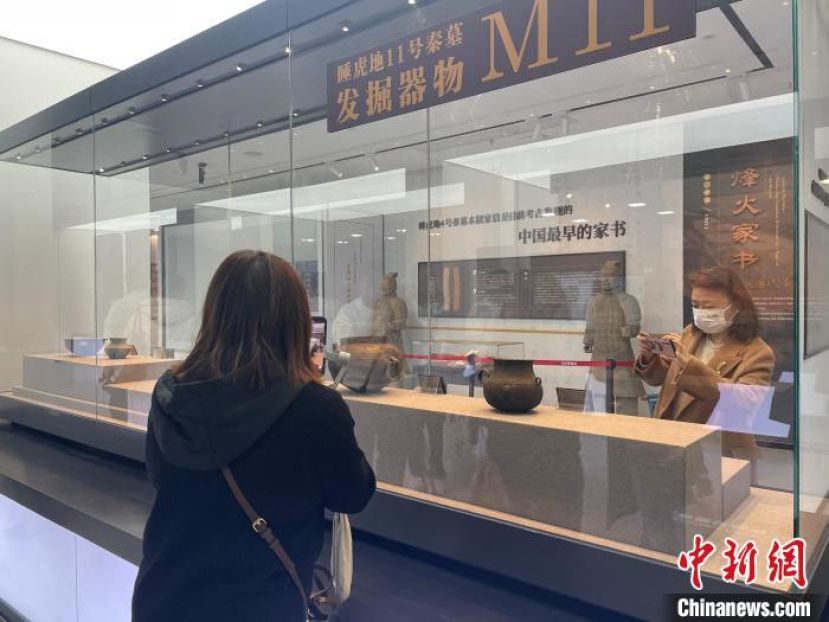 云梦县博物馆展厅中，游客正在观看文物。