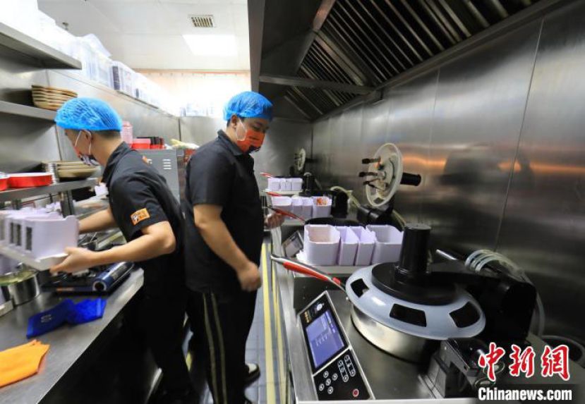 四川成都一家运用智能炒菜机的餐饮店。