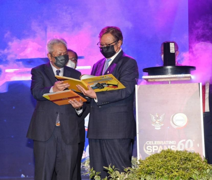 公共服务委员会主席拿督卜化沙里夫（中）向砂首长阿邦佐哈里（右）介绍该委员会 60 周年庆典时推出的2本新书时摄。  &nbsp;