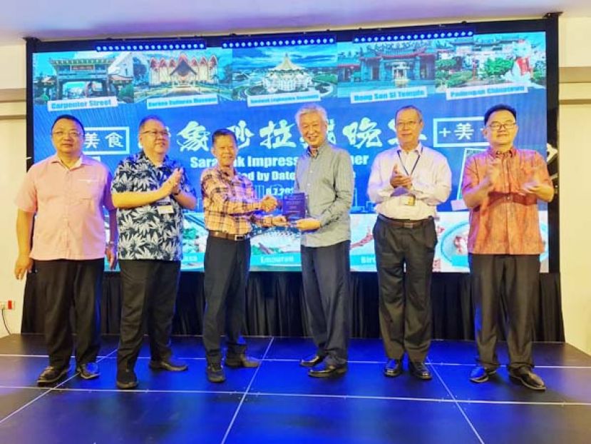 砂中总会长拿督陈日枝（左三）赠送纪念品予中总会长丹斯里拿督卢成全上议员（右三）。左一起为总秘书拿督蔡文铎、砂中总副会长兼古晋中总署理会长拿督黄国辉。右一起为庆典工委会主席田松茂与古晋中总副会长郭应茂。