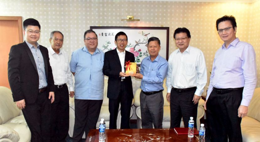砂拉越中华总商会署理会长陈日枝（右三）赠送纪念品给珠海市驻东南亚（马来西亚吉隆坡）经贸代表处首席代表宋延亮（中）。 左起;为该经贸代表处业务代表颜瑫、该总商会理事高伟宁及拿督黄国辉；右起;为该总商会理事何修华及魏铭辰博士。