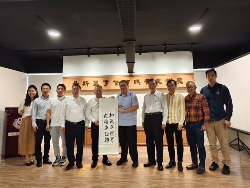 砂拉越古晋中华中学校友会会长拿督黄国辉（右五）赠送墨宝予华南师范大学副校长，东南亚研究中心主任，教授吴坚（左五）。