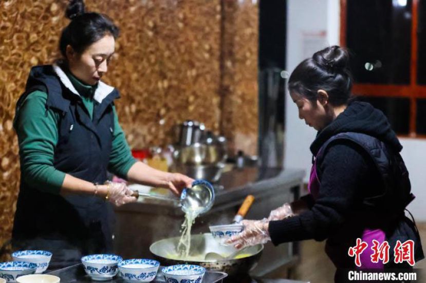 西藏芒康，果拉卓玛(左)在为食客盛加加面。