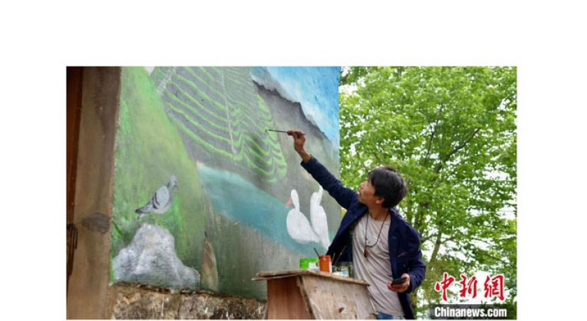 杨军昌为老房子墙面作画。