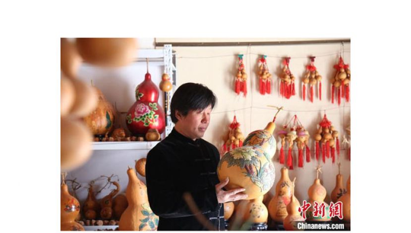 馆陶县艺人闫继法在检查制作完成的葫芦作品。