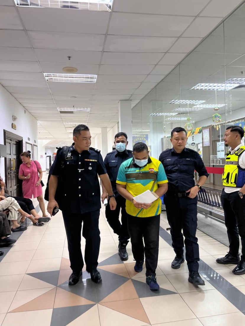 警员将被告押离法庭时摄。