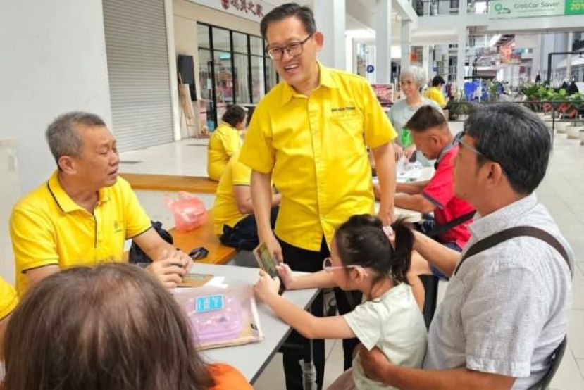 砂人联党峇都林当支部东哥团队负责人薛华东（中）贴近民心提供服务。