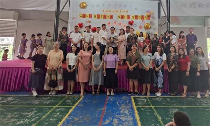 在校董们的陪同下，六小校友会主席施尚锋（台上左五）赠送教师节礼品，并由校长邓群娇接收时影。