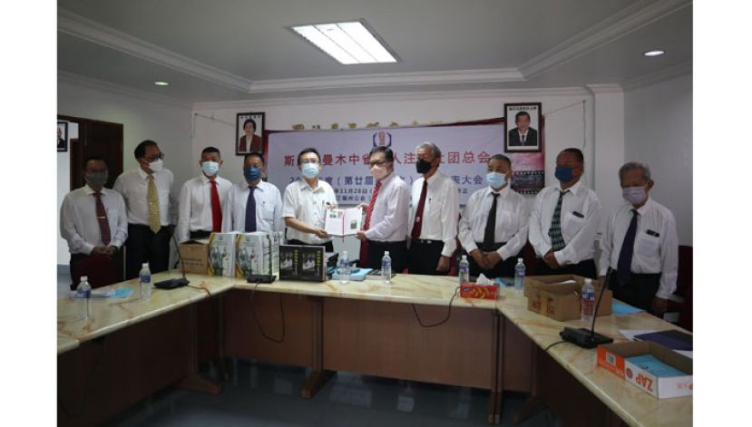 成邦江顺兴公会秘书吴诰赐（左5）赠送由该会出版的《清风拂鲁江》陈宗明传记予斯木省华总。由会长拿督吴标生博士接收。