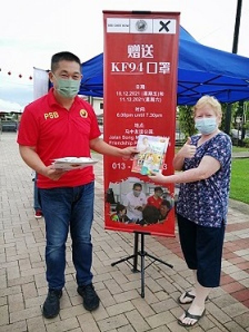 砂全民团结党巴都林当州选区候选人施志豪（左）赠送防疫口罩给民众。   