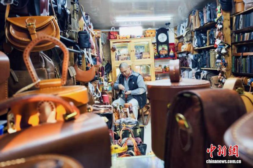 在天津市河北区王串场街&ldquo;修补巷&rdquo;，皮具修复师李涛为顾客修复皮具。
