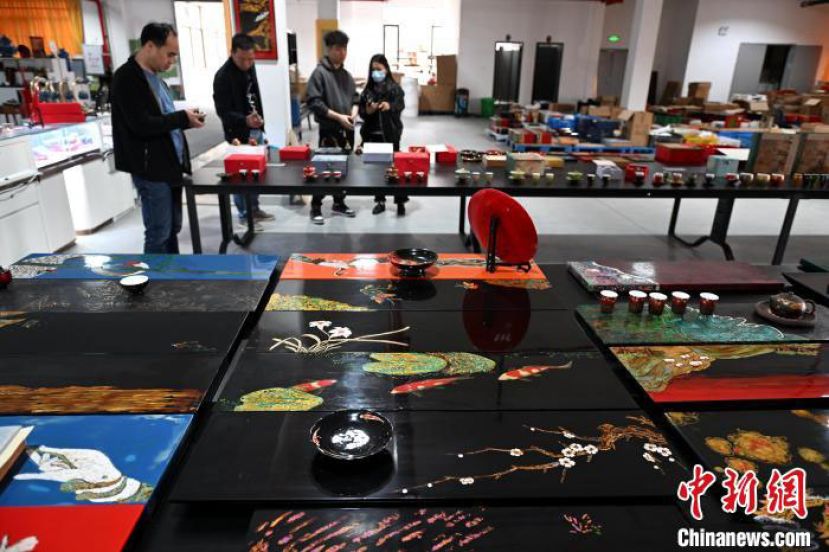 走进位于福建省福州市闽侯县竹岐乡榕西村的太古大漆脱胎漆器空间艺术馆，旅美华侨程千帆(右二)正在为游客介绍漆艺作品。