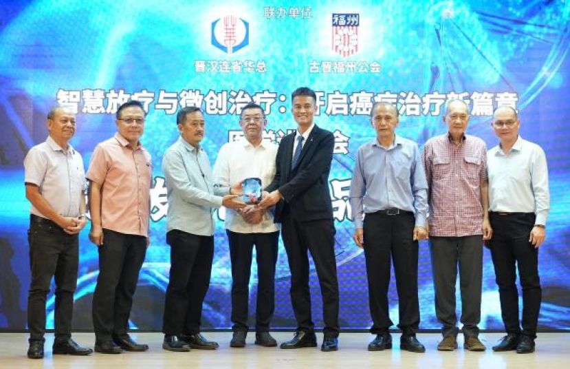 筹委会主席吴孟敦赠送纪念品予讲师李祥，由会长拿督斯里黄良杰见证，随后与全体嘉宾合影留念。左一：副会长兼甲必丹 蔡永能 左二：副会长 陈瑞光 左三：筹委会主席 吴孟敦 左四：见证嘉宾 拿督斯里黄良杰 左五：讲师李祥。右三：古晋福州公会会长兼本会财政 拿督余志豪 右二：本会副会长 高伟宁 右一：GS Health Consultancy 执行长 杨汉林。