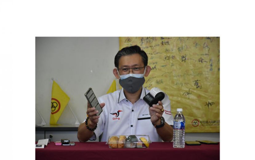 薛华东展示采用手机连接迷你打印机，登入选委会官网协助选民查询投票中心与投票站。