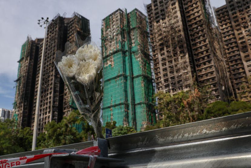 香港宏福苑大火现场，人们摆放花束悼念罹难者。