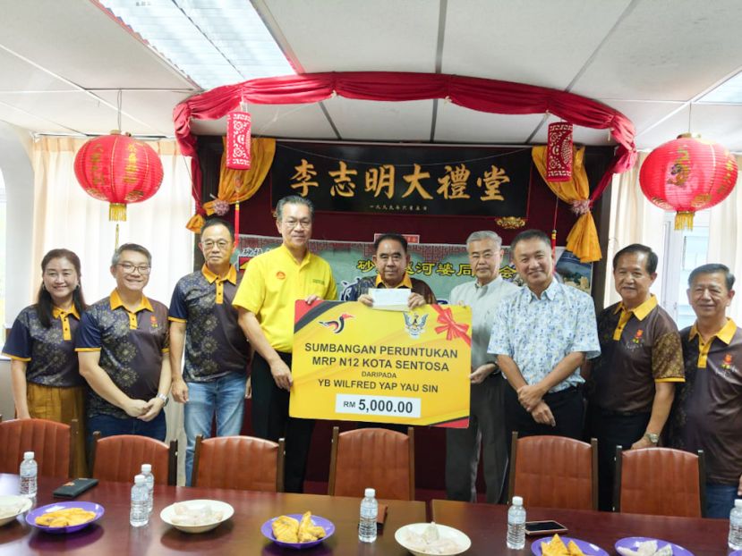 哥打圣淘沙区议员叶耀星（左四）移交5000令吉拨款予砂河婆同乡会会长天猛公刘石星（左五）。左一起为妇女组主任拿汀刘慧玲、青年团长刘贚语、署理会长拿督李启辉，右一起为西连工委会主席刘道生、砂河婆同乡会斯里阿曼分会会长本曼查李祥禾、大马河婆文化基金会主席张添堡、名誉会长拿督斯里蔡展文。