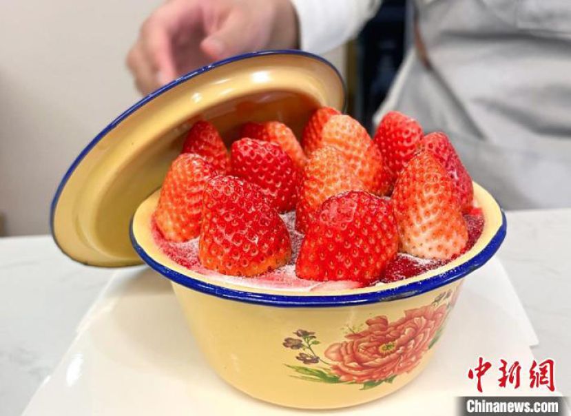 山东烟台一家甜品店，烘焙师展示刚做好的搪瓷盆草莓蛋糕。