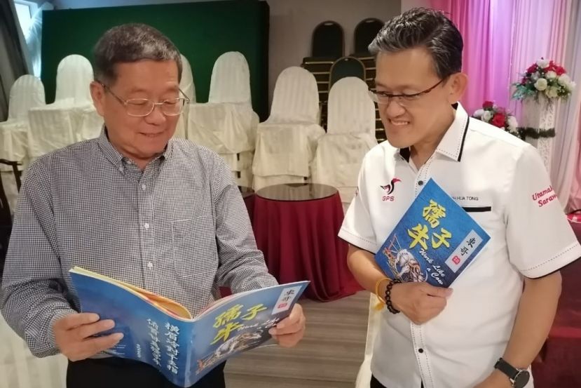  砂盟峇都林当候选人薛华东（右）与拿督邓伦奇先睹将推介《东哥、孺子牛》一书。