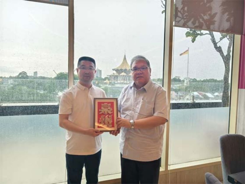 泉州市人民政府办公室副主任连景忠（左）赠送纪念品予砂拉越中国友好协会常务副会长黄国辉（右）。